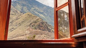An open wooden window with a view of a mountainous landscape. - Hotel Pakaritampu (Ollantaytambo)