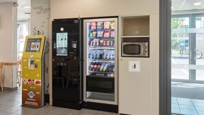 Ein Getränke- und Snackautomaten, eine Mikrowelle und ein Selbstbedienungsterminal.