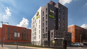 Ein modernes Bed and Breakfast Hotel mit auffälligem Schild, einem verschlossenen Eingang und einem Parkplatz.