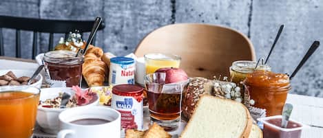 A breakfast table with various food items and drinks.