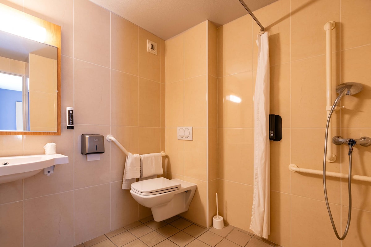 A bathroom with a toilet, sink, and shower.