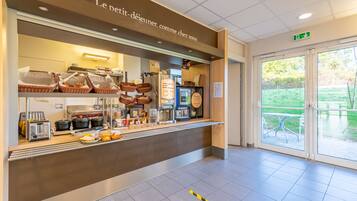 A breakfast buffet area with baskets of food, a coffee machine, and a toaster.