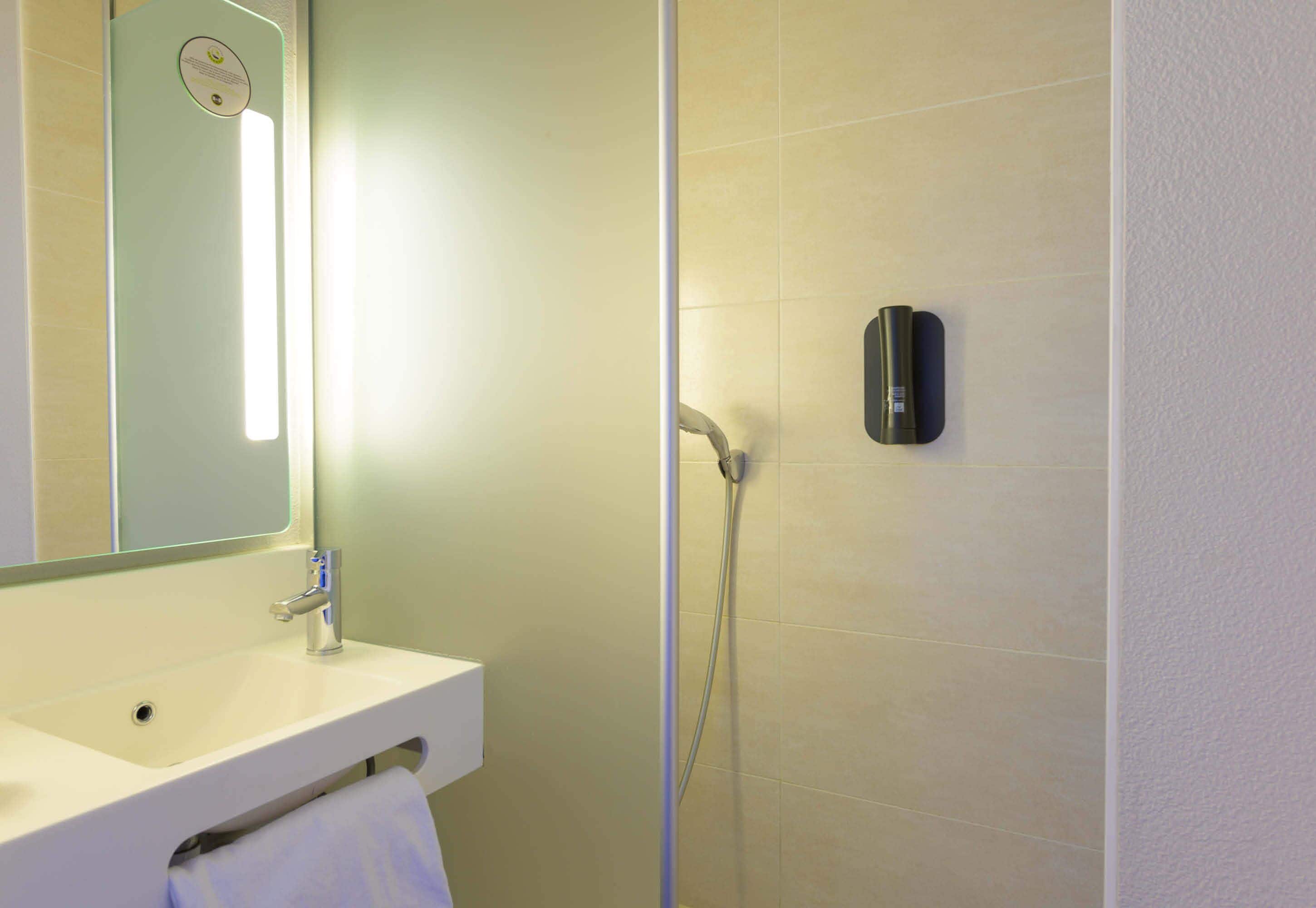 Ein Badezimmer mit Waschbecken, Spiegel und Dusche.