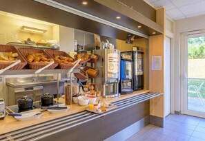 A breakfast buffet with various food items, coffee machines, and condiment dispensers. - B&B HOTEL Lieusaint Carré Sénart (Lieusaint)
