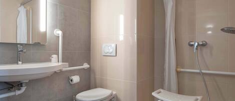 A modern bathroom with a sink, toilet, and shower.