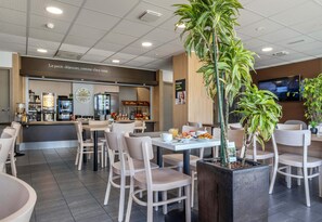 Enjoy a casual dining experience with a central table, comfortable seating, and a fully equipped kitchen area.