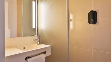 A modern bathroom with a white sink, a mirror, and a towel rack.