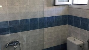 Une salle de bain équipée de toilettes, d’un bidet et d’une baignoire.