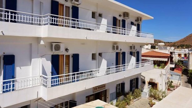 Un immeuble à plusieurs étages doté de balcons, de climatiseurs et d’une enseigne sur laquelle on peut lire « TO POON ».