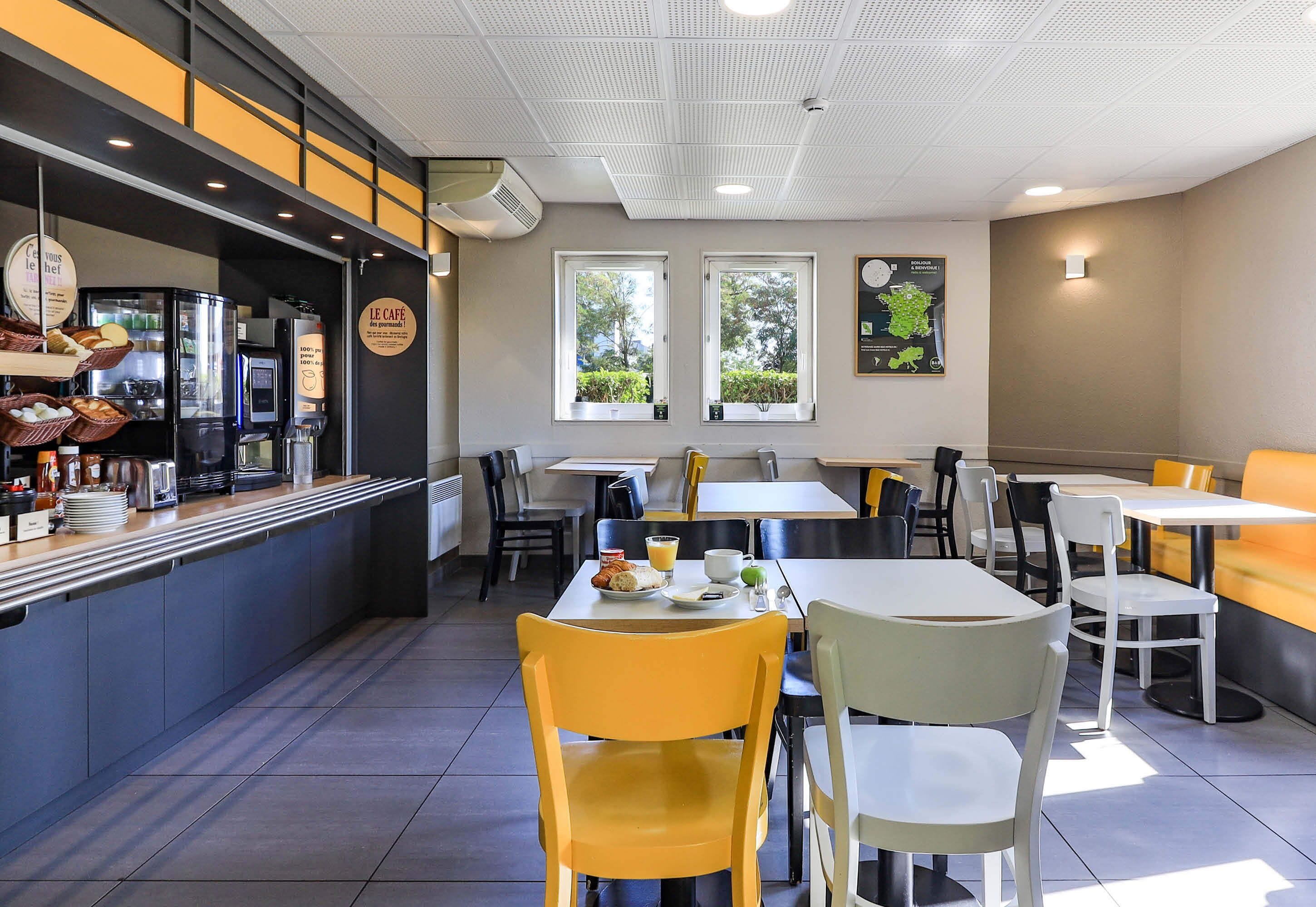 A café with a counter, seating area, and a menu board.