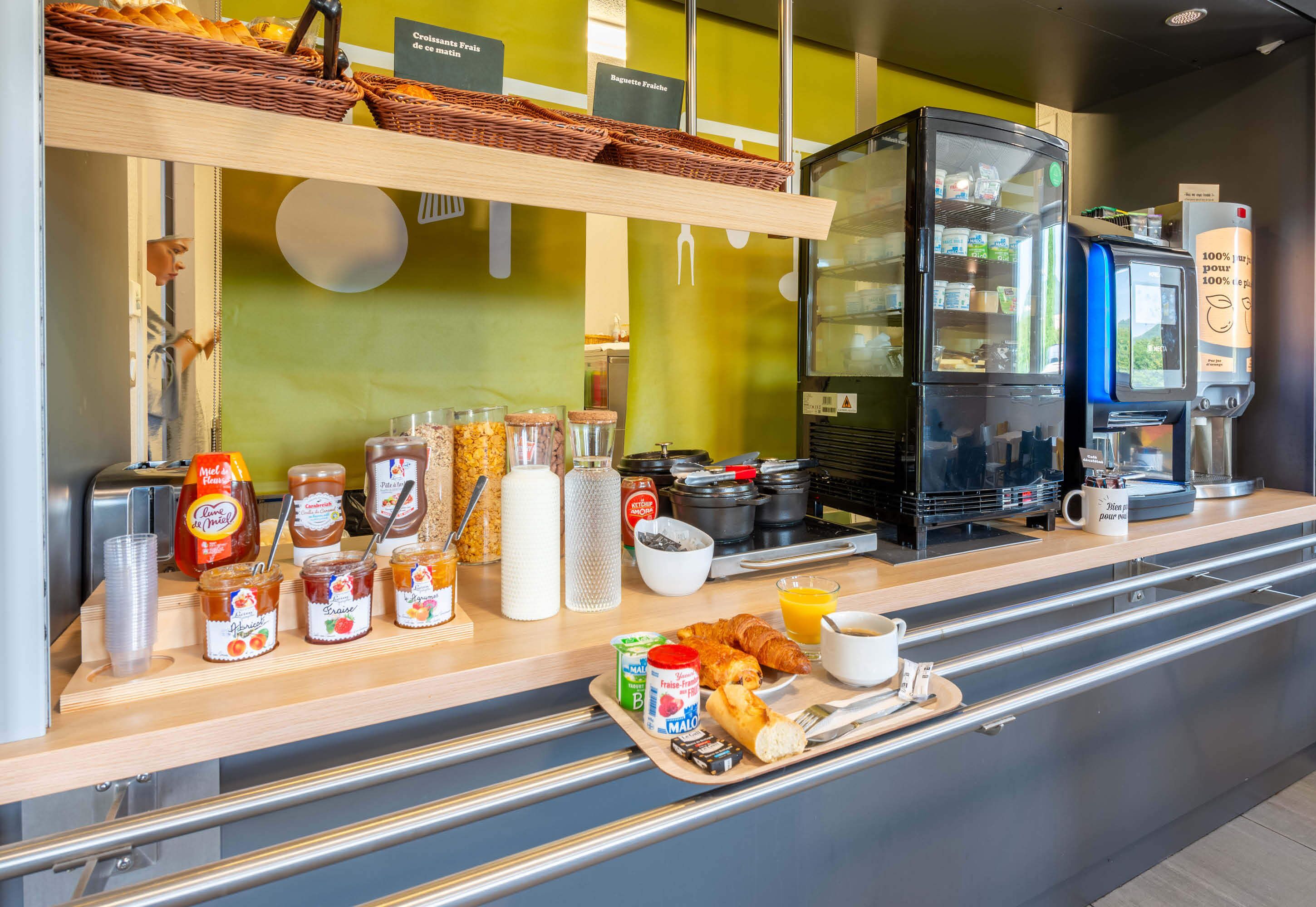 Un banco della colazione con diversi cibi, condimenti e una macchina per il caffè.