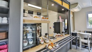 Una barra de desayuno con diferentes alimentos y una máquina de café.