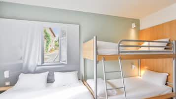 Habitación con literas, un cuadro en la pared, una mesita de noche y una mesilla.