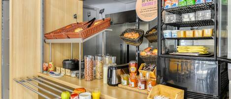Una barra de desayuno con diversos alimentos, como pan, frutas y salsas.