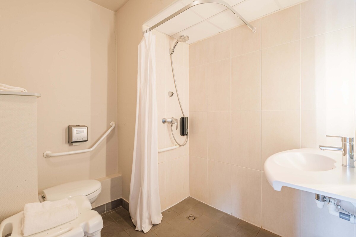 A bathroom with a shower, toilet, and sink.