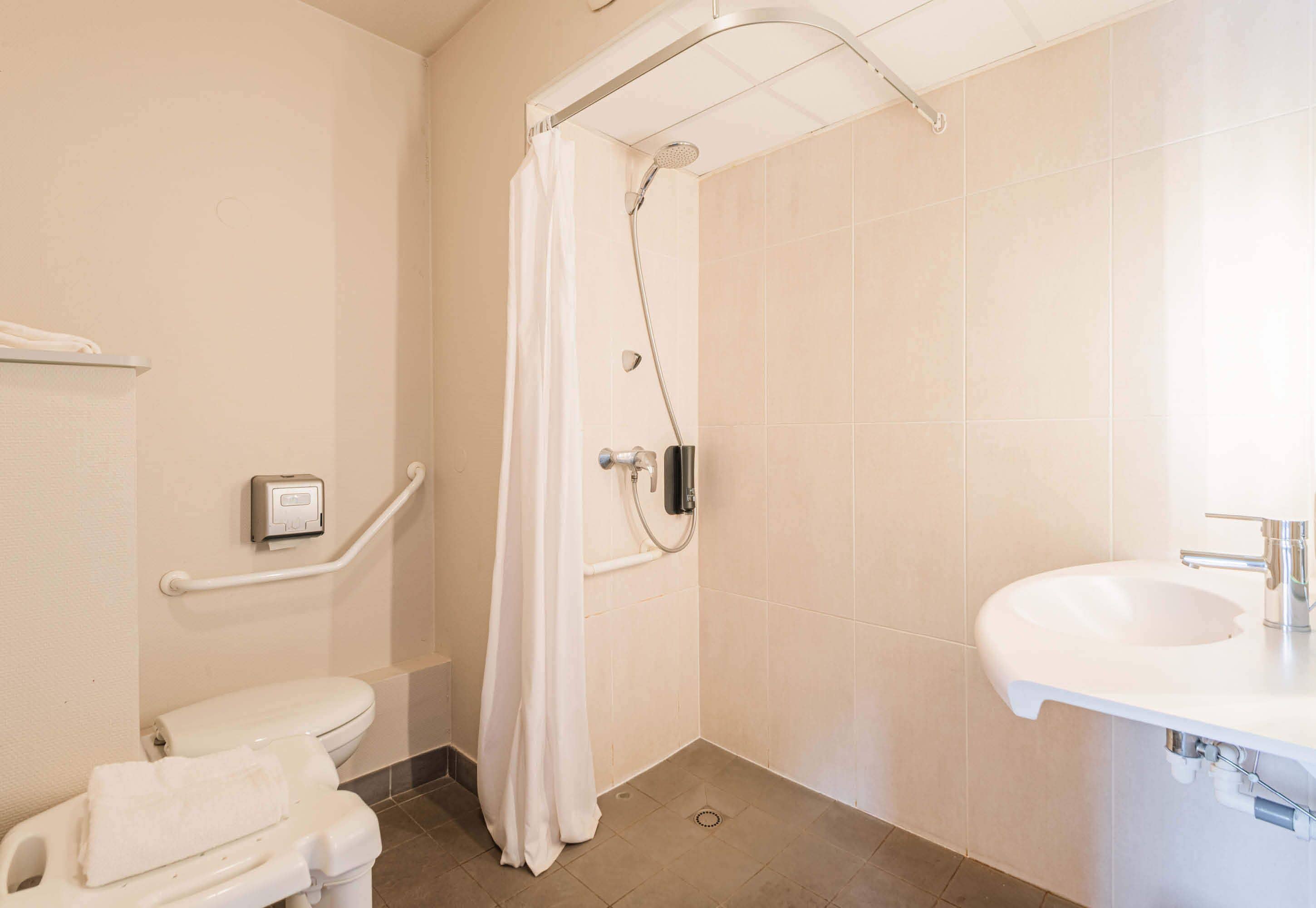 A bathroom with a shower, toilet, and sink.