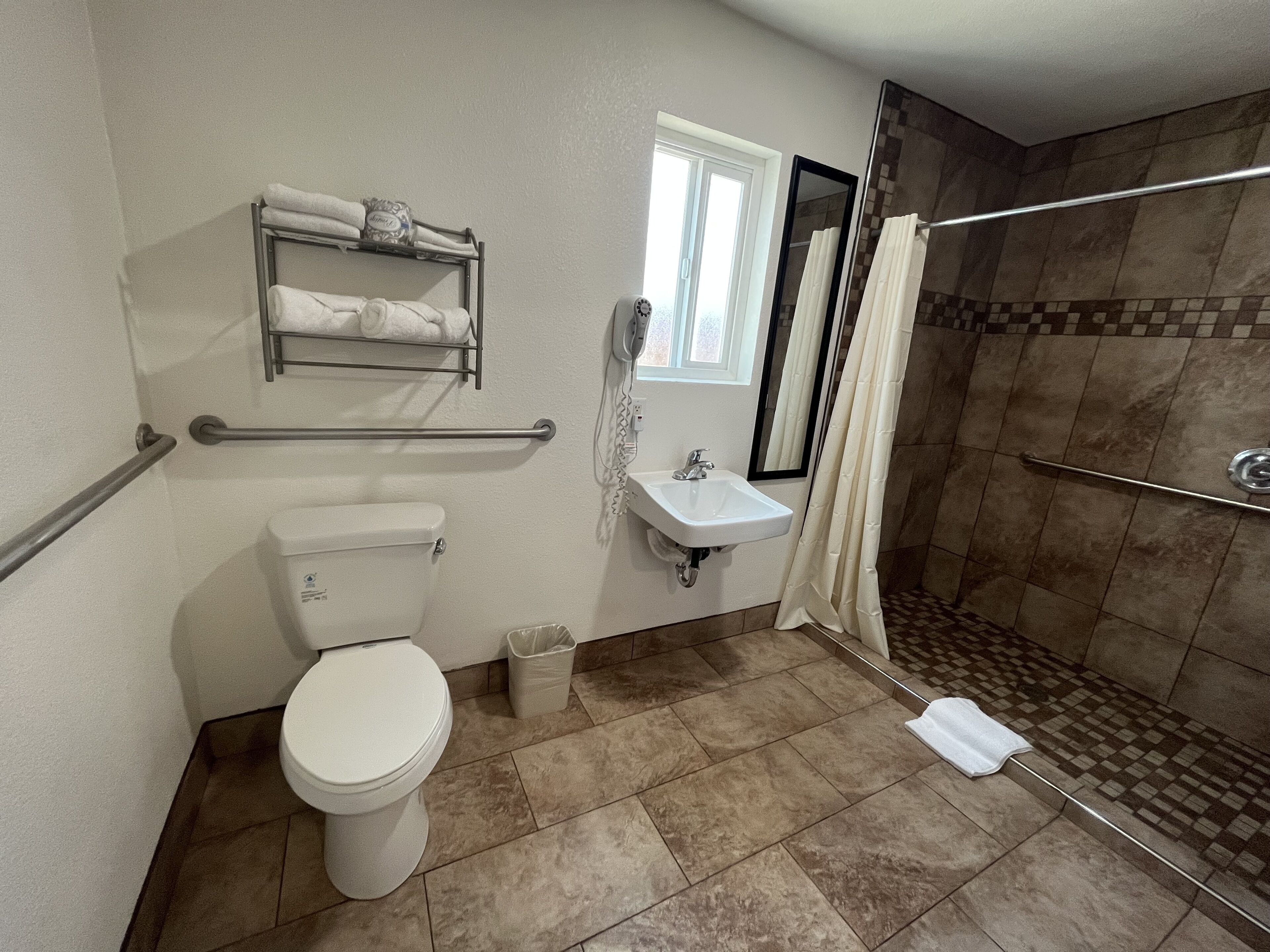 A bathroom with a toilet, sink, and shower.
