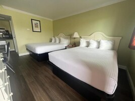 Una habitación de hotel con dos camas, un escritorio y una silla.