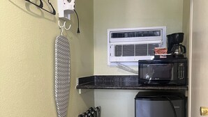 A compact kitchen with a microwave, coffee maker, and a refrigerator.