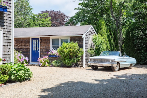 A two-story house with a blue door and a white car parked in front. - The Lightkeepers Inn (Edgartown)