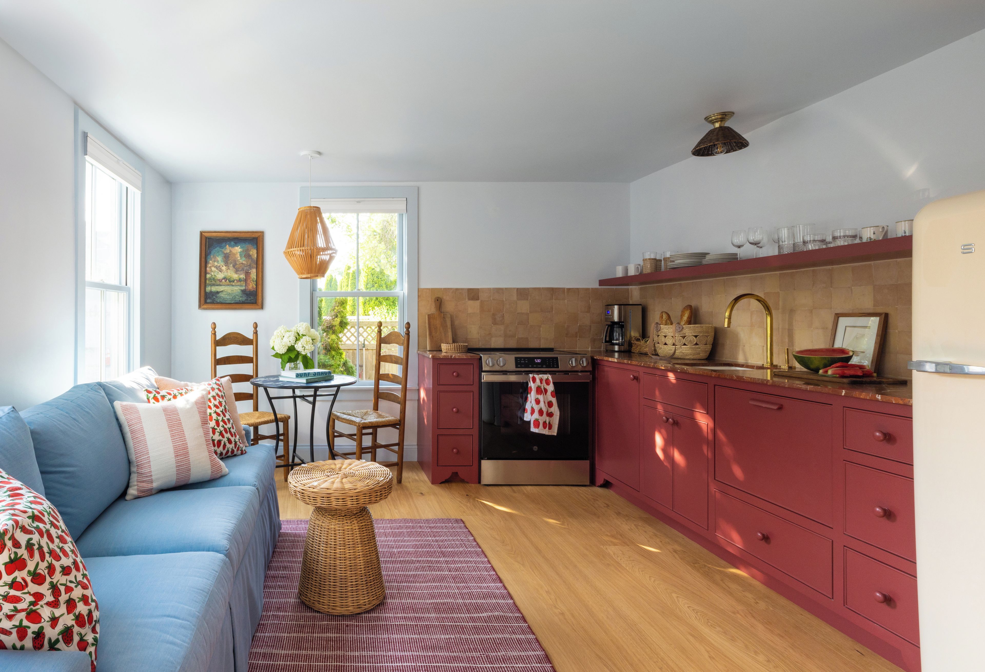 A compact living space with a kitchenette, a dining area, and a seating area with a sofa and chairs.