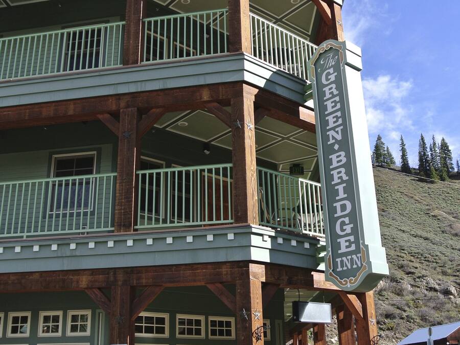 Un edificio de dos pisos con un balcón y un cartel que dice "The Green Bridge Inn".