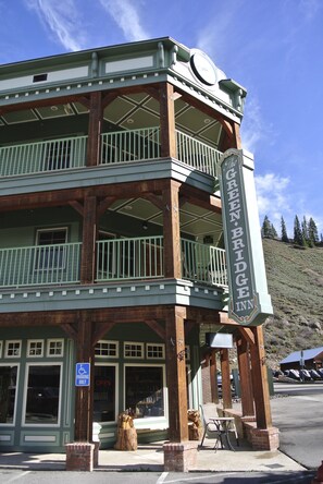 A two-story building with a balcony and a sign reading "The Green Bridge Inn".