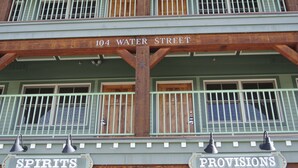A building with a sign reading "104 Water Street" and two signs below it labeled "Spirits" and "Provisions". - The Green Bridge Inn (Red Cliff)