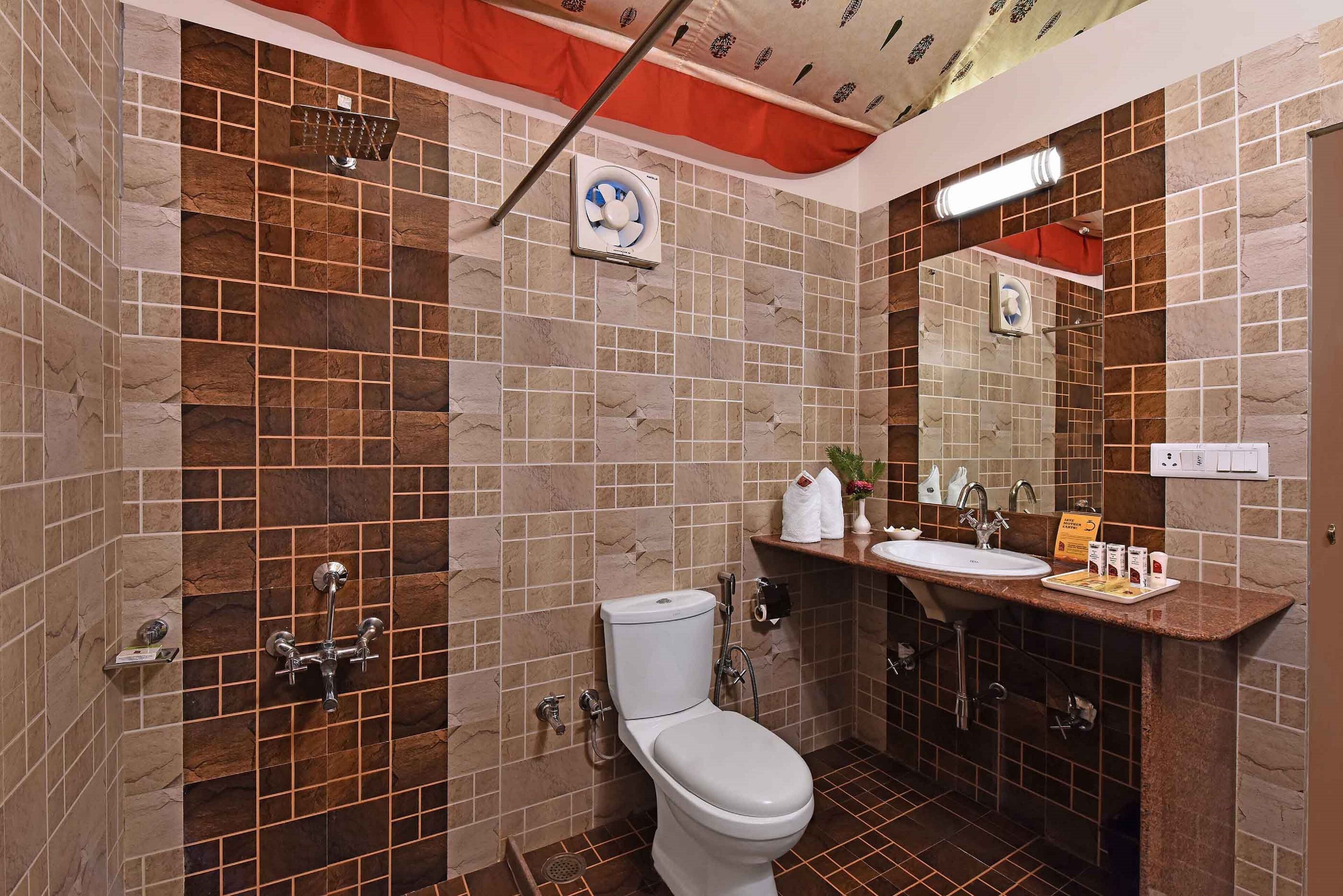 Une salle de bain avec des toilettes, une douche et un lavabo.