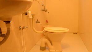A bathroom with a toilet, sink, and shower. - Hotel Dreams (Thiruvananthapuram)