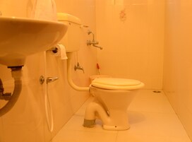 Un baño con inodoro, lavabo y ducha.