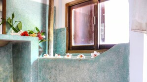 Un baño con ventana, lavabo y espejo.