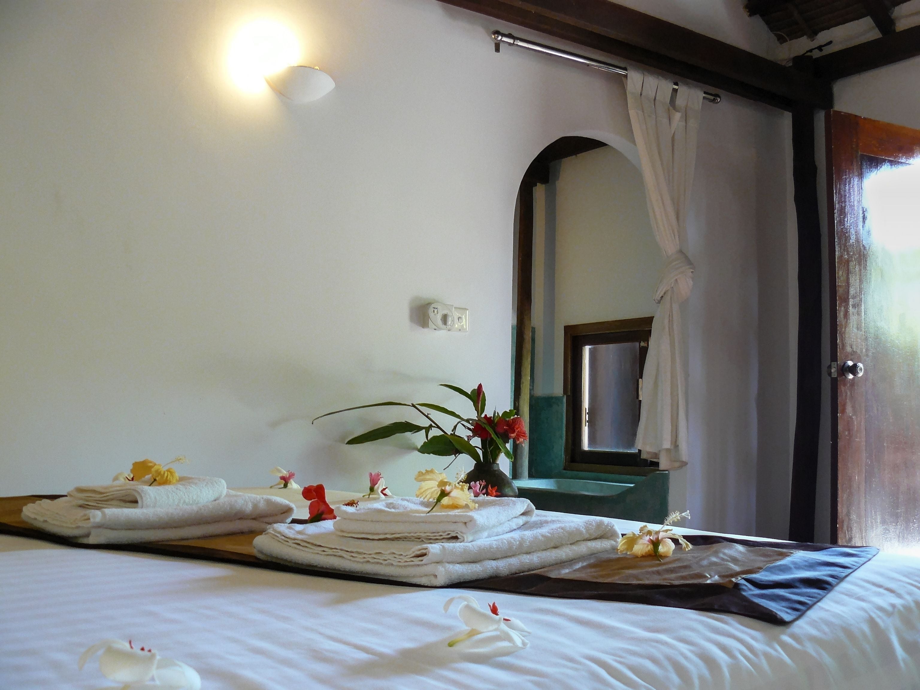 Una habitación de hotel con cama, toallas y un espejo.
