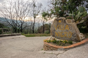 A stone sign with "VILLA NIGRO" written in yellow.