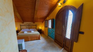Une chambre à coucher avec un lit, des tables de chevet, une fenêtre et une porte.