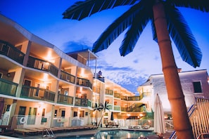 A multi-story hotel with balconies, a swimming pool, and palm trees. - Ala Moana Motel (Wildwood)