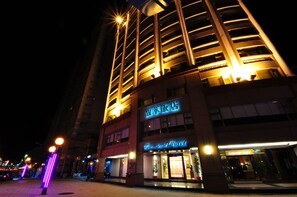 A hotel with a modern facade, multiple floors, and illuminated signage indicating a restaurant and a lounge cafe. - Forward Hotel (New Taipei City)