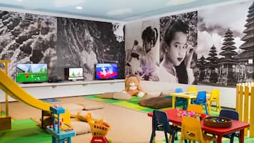 Kids can play and watch their favorite shows on two flat-screen TVs, with a fun play area featuring a slide, play structure, and toy shopping cart.