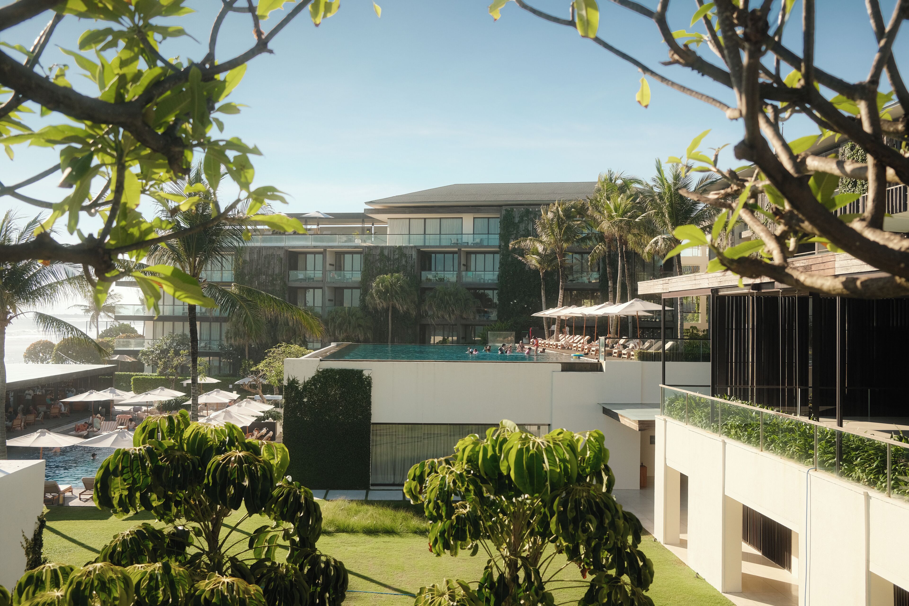 Ein modernes Hotel mit Poolbereich, Außenbereich und üppiger Bepflanzung.