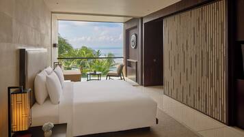 A modern hotel room with a large bed, a balcony with a view of the sea, and a traditional sliding door.