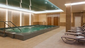 A spa area with a hot tub, lounge chairs, and a tiled floor. - Grand Resort Jermuk (Jermuk)