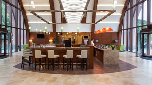 A spacious lobby with a central bar area, large windows, and modern lighting fixtures. - Grand Resort Jermuk (Jermuk)