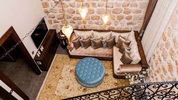 A cozy living area with a sofa, ottoman, and decorative lighting.