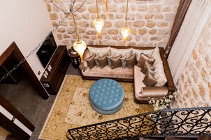 A cozy living area with a sofa, ottoman, and decorative lighting.