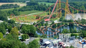 A roller coaster with multiple tracks and a steep drop, surrounded by greenery and a body of water. - Quality Inn & Suites Ruther Glen (Ruther Glen)