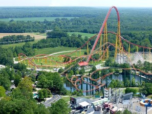 A roller coaster with multiple tracks and a steep drop, surrounded by greenery and a body of water. - Quality Inn & Suites Ruther Glen (Ruther Glen)
