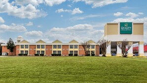 A hotel with a green sign reading 'Quality Inn & Suites' and a brick facade. - Quality Inn & Suites Ruther Glen (Ruther Glen)