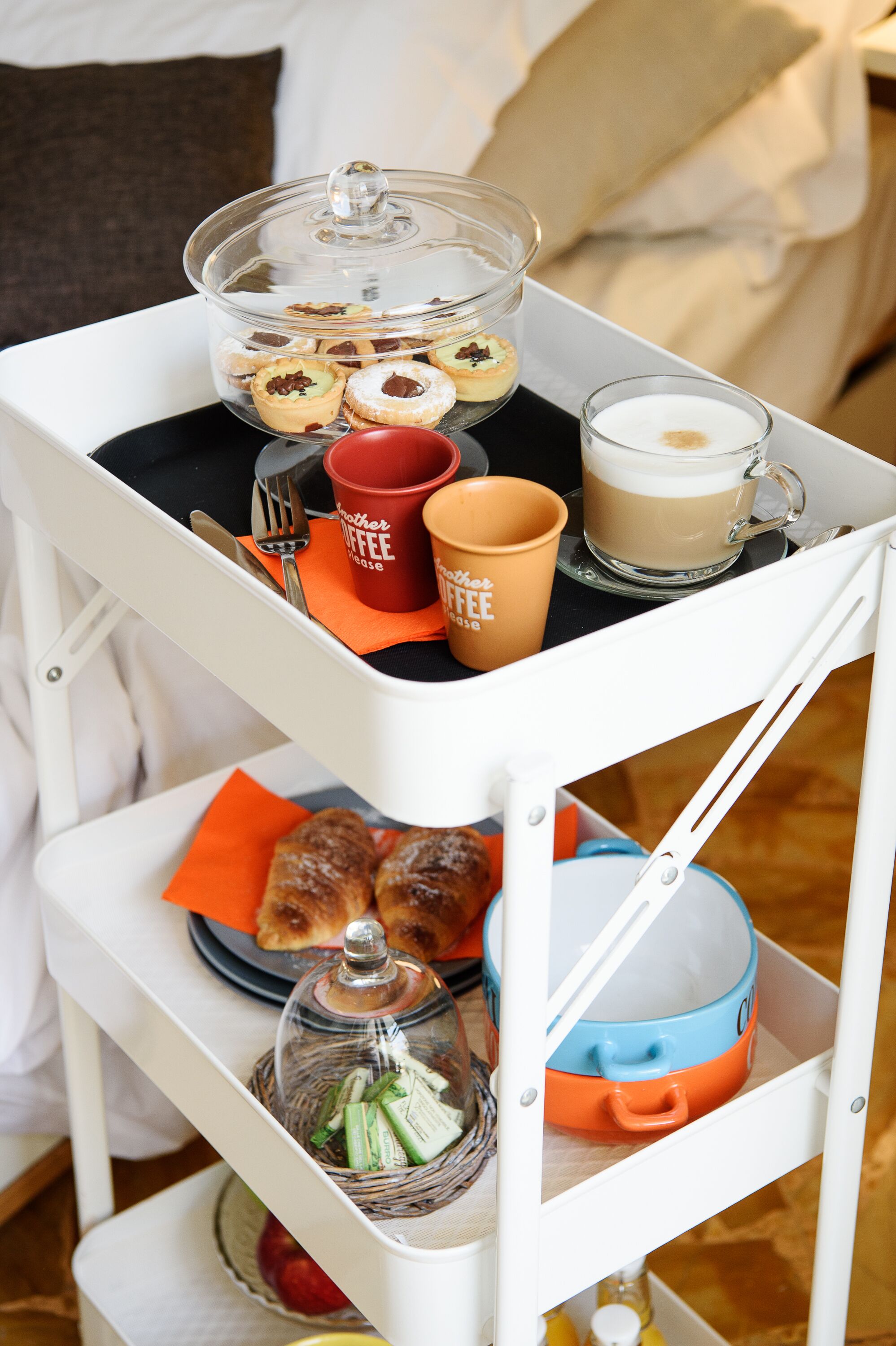 Ein Frühstückswagen mit Gebäck, Kaffee und einem Glas Milch.