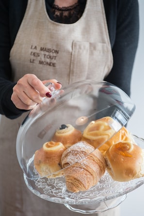 Una persona sosteniendo un bol transparente lleno de pasteles.