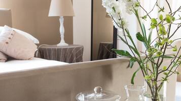 Quarto de hotel com disposição para café da manhã, incluindo cereais, ovos, leite e um vaso com flores.